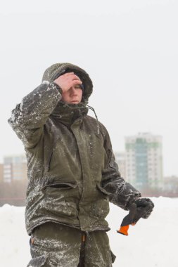 Ocak ayında donmuş bir nehrin buzunda bir inşaatçının portresi.