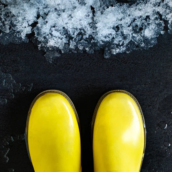 Yellow Rubber Boots Front Melting Snow Black Background Spring Concept — Stock Photo, Image