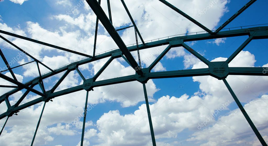 Bridge spans in the background of clouds and blue sky.