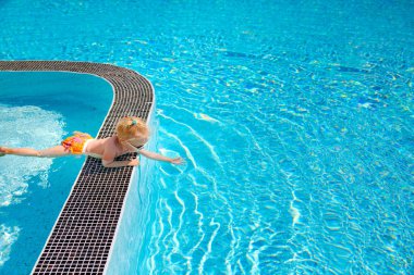 Su dokunmadan havuzun kenarında, yalan küçük sevimli sarışın bebek kız,.