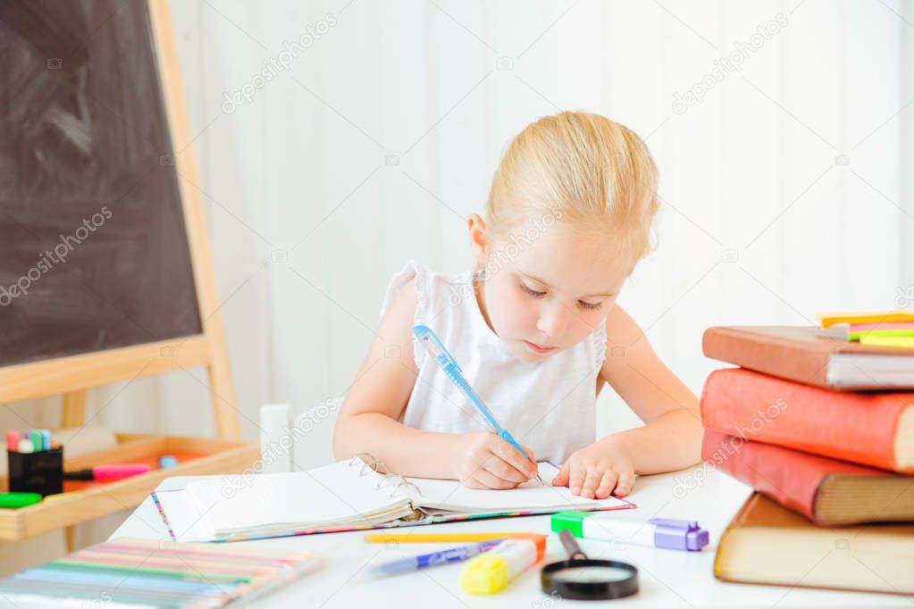 Little girl looking focused and concentrated on doing her homework.