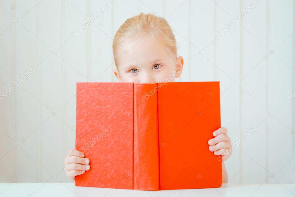 Little girl behind of big red book