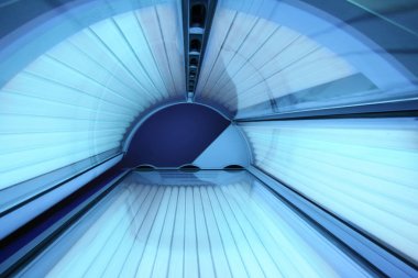 Modern güzellik salonunda solaryum boş solaryum yatağı, kapalı kapaklı içeriden görüş ve tüm ampuller yanıyor. Güneş banyosu, güzellik yaşam tarzı ve sağlık hizmetleri kavramı
