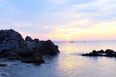 Denizde renkli gökyüzü günbatımı kızdırma.