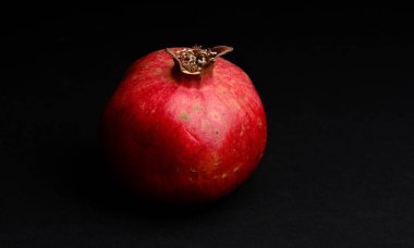 Siyah bir zemin üzerine taze kırmızı nar