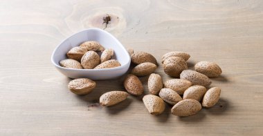 Ahşap masa üzerinde beyaz kabuklu badem