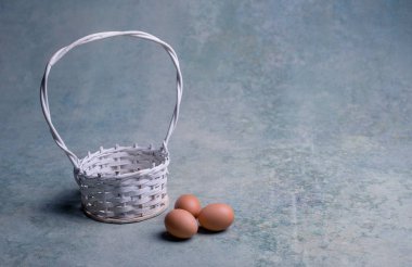Beyaz sepet ve üç tavuk yumurtası. Paskalya kavramı