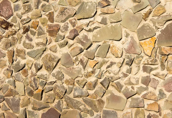 Chipped natural stone is laid in a powerful wall, a great backgr — Stock Photo, Image