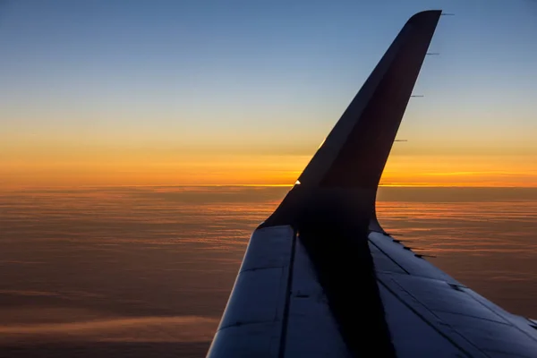 Tired evening sun is hiding behind the wing of the plane before — Stock Photo, Image