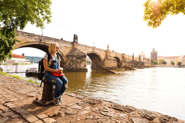 Viajante do sexo feminino desfruta de vistas para a Ponte Charles em Praga — Fotografia de Stock