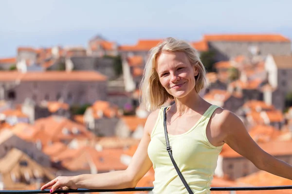 Mooie jonge blonde meisje op een achtergrond van wazig panoramisch stadslandschap. Dubrovnik — Stockfoto