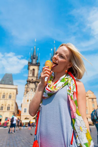 Tyn 대성당의 배경에서 아이스크림을 먹는 여자 — 스톡 사진