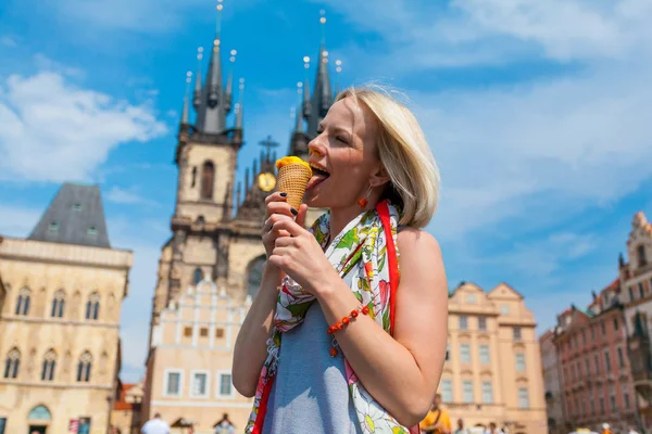 Woman eating ice cream on a background of Tyn Cathedral — Stock Photo, Image
