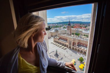 Krakow şehrinde Pazar Meydanı, pencereden arayan kadın