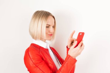 Portrait of woman with mobile phone in red jacket on white background clipart
