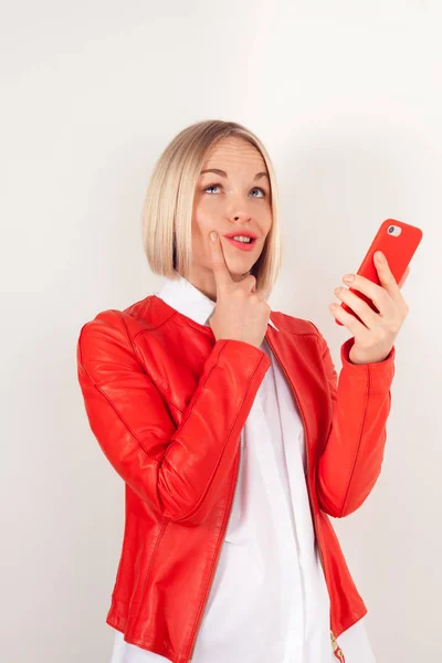 Cep telefonu beyaz zemin üzerine kırmızı ceketli olan kadın portresi — Stok fotoğraf