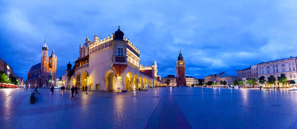 Cloth Hall well known as sukiennice, St. Marys Church and the Clock Tower at night. Panoramic view of Market Square - main square in old city. Krakow Poland.