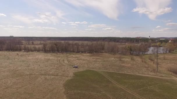 Vliegen over het veld waarop het voertuig reist. Luchtfoto. 4k video — Stockvideo