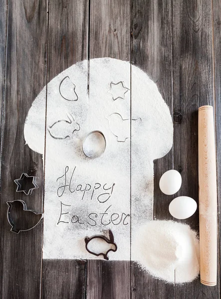Symbolic image Easter cake with utensils on a dark wooden background.