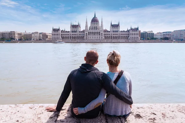 İki kişi Rıhtımlar üzerinde oturmak ve Budapeşte, Meclis'te manzarasının keyfini çıkarın