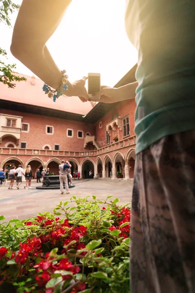 A woman stands in the courtyard of the university and takes pictures of him on a mobile phone — Stock Photo, Image