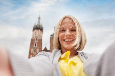 Young beautiful woman on the background of the St. Marys Church in Krakow clipart