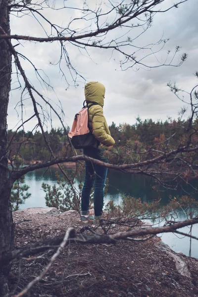Mladá dívka s batohem se kochat výhledem na jezero. — Stock fotografie
