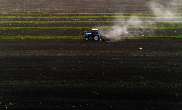 Trattore campo di coltivazione a primavera, vista aerea — Foto Stock