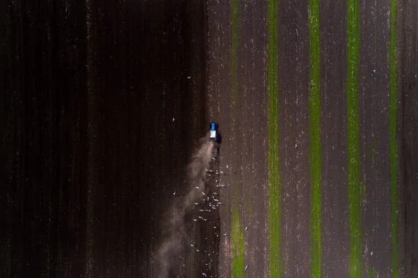 Campo de cultivo de trator na primavera, vista aérea — Fotografia de Stock