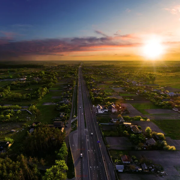 Вид з повітря на автомагістраль в районі села на заході сонця — стокове фото