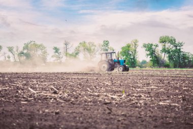 Güzel bir gün batımı gökyüzü karşı ilkbaharda bir alan traktör pulluklar