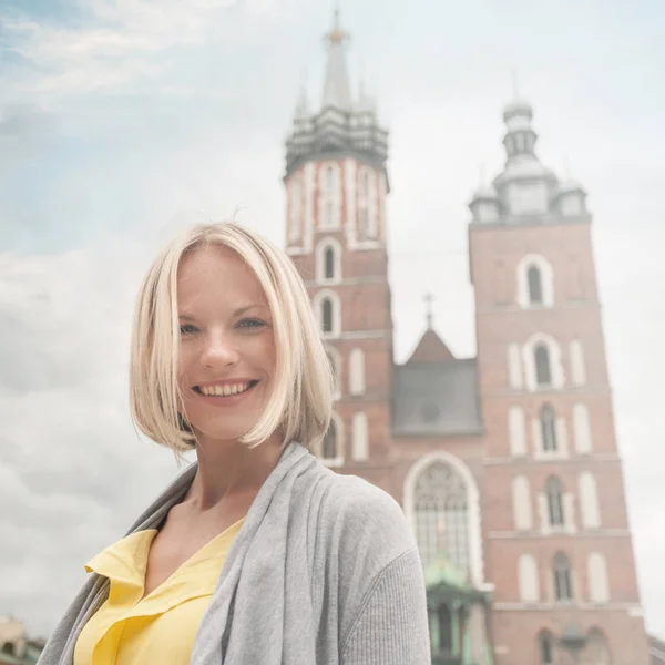 年轻美丽的女子，在圣玛莉教堂在克拉科夫的背景 — 图库照片