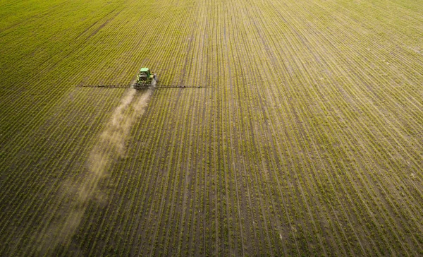 El tractor rociando el campo con productos químicos en la primavera —  Fotos de Stock