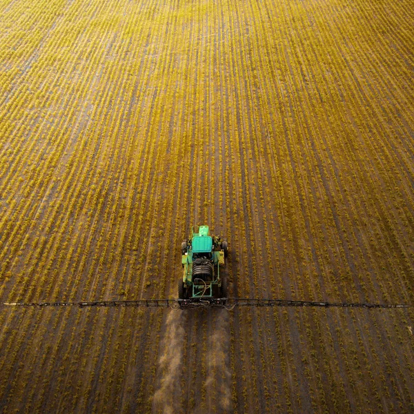 Il trattore spruzza il campo con sostanze chimiche in primavera — Foto Stock