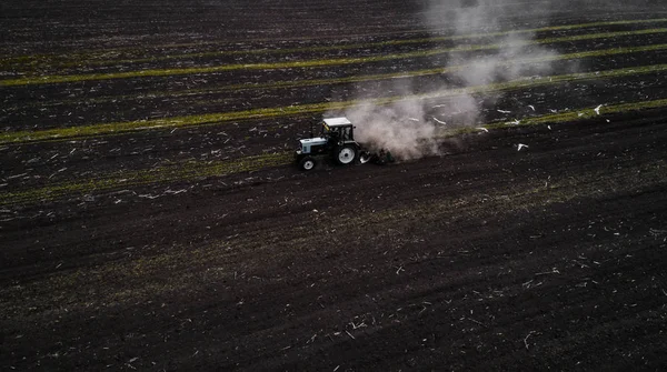 Campo de cultivo de trator na primavera, vista aérea — Fotografia de Stock