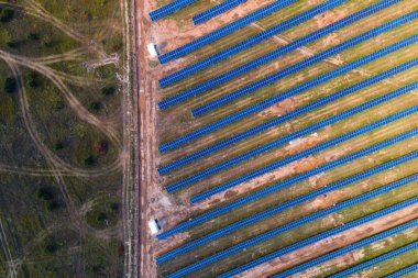Kırsal bir çayıra yerleştirilmiş güneş panelleri.