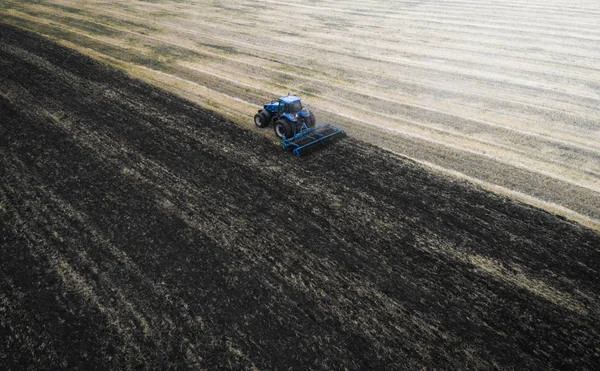 Campo de cultivo de trator na primavera, vista aérea — Fotografia de Stock