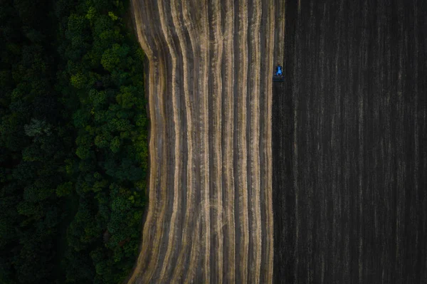 Campo de cultivo de trator na primavera, vista aérea — Fotografia de Stock