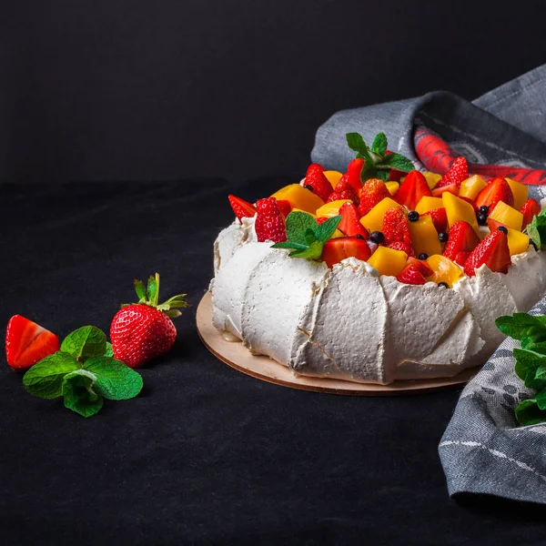 Pavlova cake on dark background.