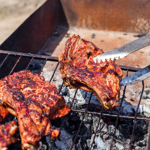 A férfi kezét grill sült hús. — Stock Fotó