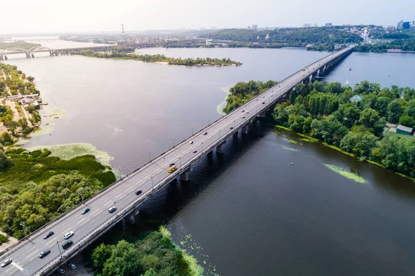 Luftaufnahme der Brücke und der Straße über den Fluss dnepr über eine grüne Insel in der Mitte des Flusses — Stockfoto