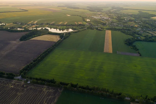 Панорамний вид на долину з зеленими свіжими полями і лугом на заході сонця . — стокове фото