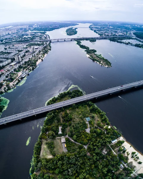 Aerial view of the bridge and the road over the Dnepr River over a green island in the middle of the river — Stock Photo, Image