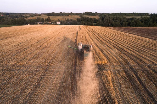 Maaimachine werkt in veld en maait tarwe. Oekraïne. Luchtfoto. — Stockfoto