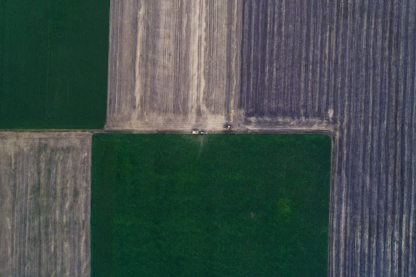 Vista aérea de la cosechadora, que vierte el grano en el remolque para su posterior procesamiento . — Foto de Stock