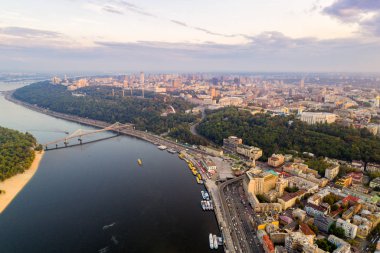 Panoramik Podol ilçe, şehir merkezi ve Vladimirskaya Gorka. Kiev Dinyeper Nehri, bir yaya köprüsü ve gün batımında geniş park alanı ile değil bankanın genel görünümü.