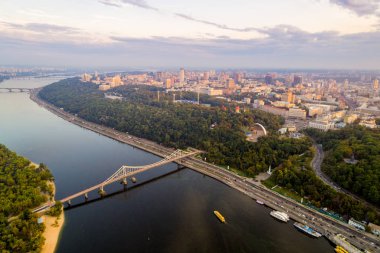 Panoramik Podol ilçe, şehir merkezi ve Vladimirskaya Gorka. Kiev Dinyeper Nehri, bir yaya köprüsü ve gün batımında geniş park alanı ile değil bankanın genel görünümü.