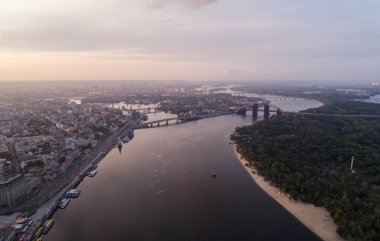 Panoramik manzaralı bir nehir, bitmemiş Köprüsü ve Şehir Parkı parçası ile modern bir şehir