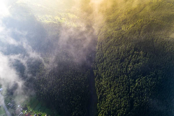 Aerial view of the village in the Carpathian mountains with clouds in the foreground — Stock Photo, Image