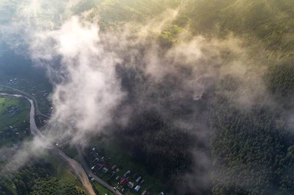Vue aérienne du village dans les montagnes des Carpates avec nuages au premier plan — Photo